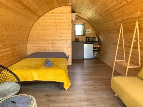 PrapuntaiKedras Glamping - Pod tipo nameliai的木制客房内的一间卧室,配有一张床