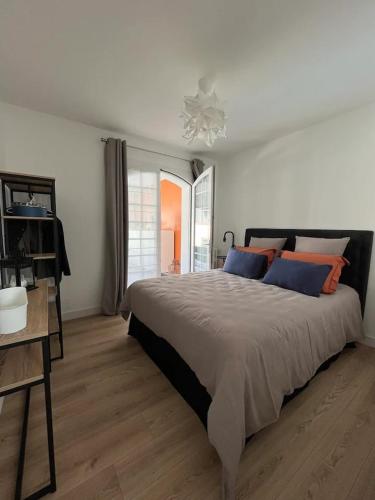 勒克鲁西克11 Port Lin的一间卧室配有一张带蓝色和橙色枕头的大床