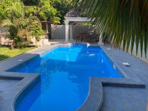 科洛里Queen Zee Garden Apartments的后院的蓝色海水游泳池