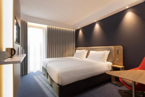 迪温特Holiday Inn Express & Suites - Deventer, an IHG Hotel的卧室配有一张白色大床和一张书桌