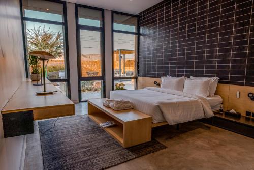 利雅德Najdarah Resort的卧室配有一张床、一张书桌和窗户。