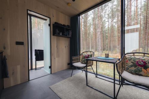 RooslepaÖÖD Hötels Rooslepa - FIKA, MYSA , SKÖNT-with sauna的一间设有两把椅子、一张桌子和一个窗户的房间
