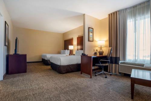 弗利弗利北部湾岸康福特套房酒店的配有一张床和一张书桌的酒店客房
