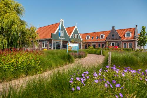 厄伊特丹EuroParcs Poort van Amsterdam的一座花园,在一座建筑前种有紫色花卉