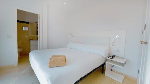 卡兰博希Lago Resort Menorca - Villas & Bungalows del Lago的白色卧室,配有白色的床和棕色袋