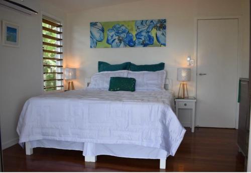 萨武萨武Island Breeze Fiji的卧室配有白色的床和墙上的绘画作品