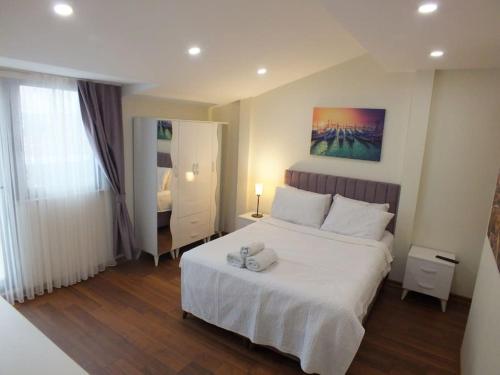 伊斯坦布尔Central Cozy Flat with Terrace & Sea View的卧室设有一张白色大床和一扇窗户。