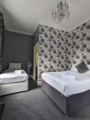 南安普敦Blue Keys Hotel Southampton的一间卧室设有两张床和鲜花墙