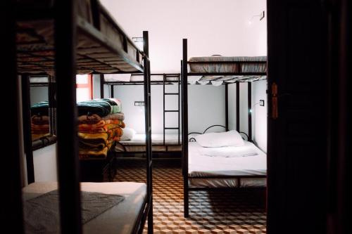 丹吉尔The Riad Hostel Tangier的一间房间,设有三张双层床