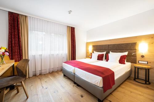 慕尼黑莱姆公园酒店的酒店客房设有一张大床和一张书桌。