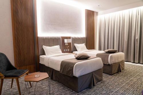 Sīdī Ḩamzahفندق ركاز الماسي - Rekaz Diamond Hotel的酒店客房,配有两张床和椅子