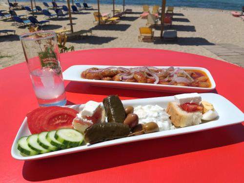 利迈纳里亚阿加利酒店的沙滩上红色桌子上的两盘食物