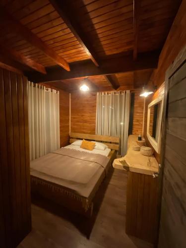 乌尔拉Panurla Wooden House havuz & sauna kırmızı的木制客房内的一间卧室,配有一张床