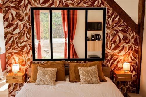 蒙托邦La Maison de Maxou的卧室配有大镜子,位于床上方