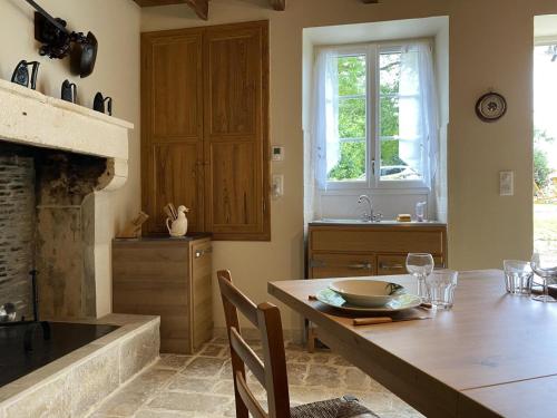 Gîte Val-de-Bonnieure, 3 pièces, 4 personnes - FR-1-653-214的厨房配有木桌和壁炉。