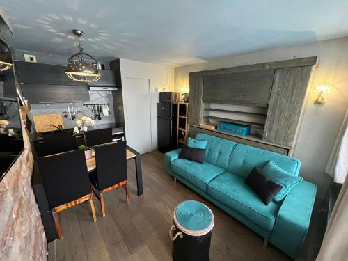 蒂涅Appt 123 Home Club Tignes的一间带蓝色沙发的客厅和一间厨房