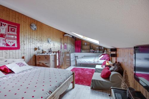 EnchastrayesL'Edelweiss - Au pied des pistes的一间带两张床和一张沙发的卧室