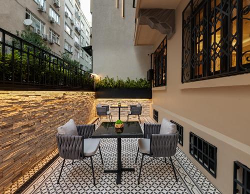 伊斯坦布尔Gleam Collection Hotel的庭院内带桌椅的庭院。