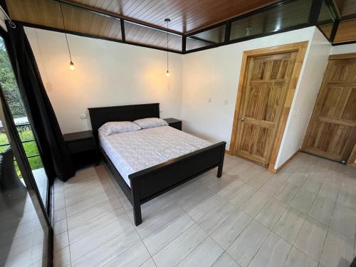 德雷克Pacheco Tours Rainforest Cabins的一间卧室配有一张床和一扇木门