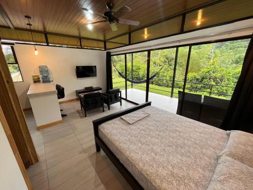 德雷克Pacheco Tours Rainforest Cabins的一间卧室设有一张床和一个大窗户