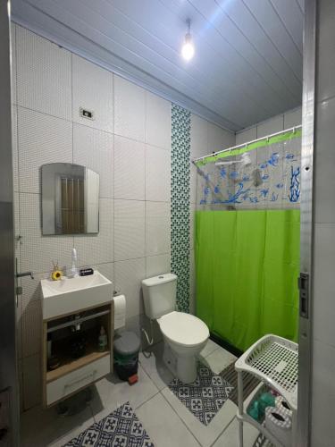 萨夸雷马Nosso Repouso Saquarema - Casa inteira com Piscina,churrasqueira privativos, Wi-fi,900m da praia, Tv-Smart.的浴室设有卫生间和绿色淋浴帘。