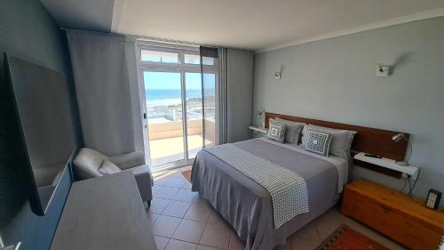 布鲁堡史特兰2WhiteWaters Bloubergstrand Homestay的一间卧室设有一张床和一个大窗户