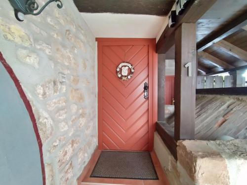 KahlaDie alte Kantorei - historische Ferienwohnung的石墙房间内的红色门