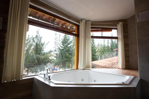 卡哈马卡Hotel Serra Nova的浴缸位于窗户前