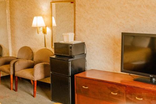 ColfaxColfax Inn By Marifah的酒店的客房配有平面电视和椅子。
