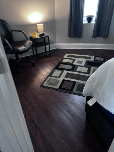 芝加哥Simplified Living Space的一间卧室配有一张床、一把椅子和地毯