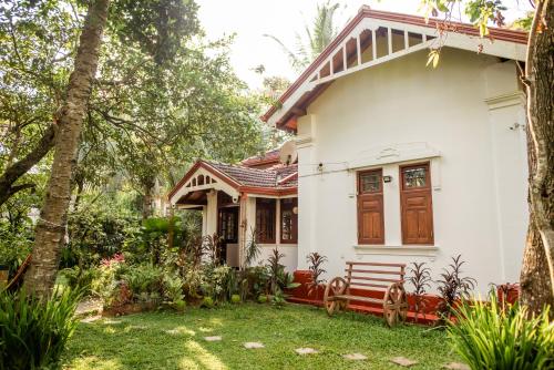 康提Colonial Residence Kandy的院子里有长凳的白色房子
