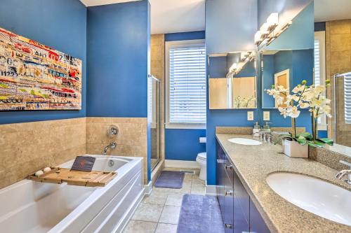 奥马哈Downtown Condo with Rooftop Patio and City Views!的浴室配有蓝色的墙壁、浴缸和水槽。