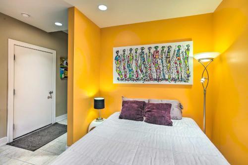 奥马哈Downtown Condo with Rooftop Patio and City Views!的一间卧室设有黄色的墙壁和一张带紫色枕头的床