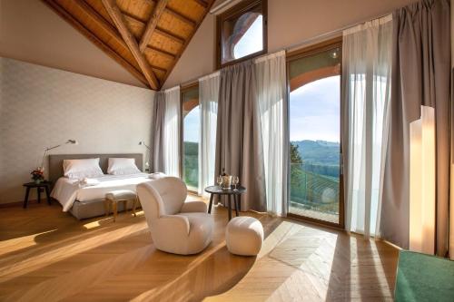 SoranoVillaggio Narrante - Cascina Galarej的一间卧室设有一张床和一个大窗户