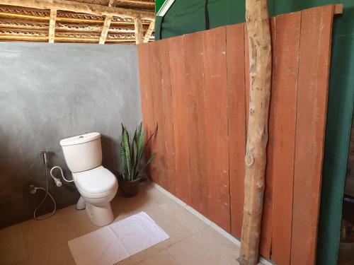 维勒珀图Nirvaan Safari Lodge的一间带卫生间和木墙的浴室