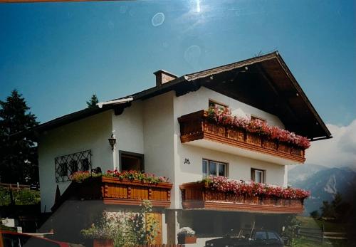 斯拉德明Haus Knauß的一座带阳台的建筑,鲜花盛开
