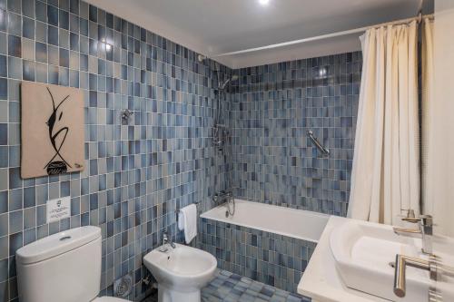 丰沙尔Casa Sta Clara的蓝色瓷砖浴室设有卫生间和水槽