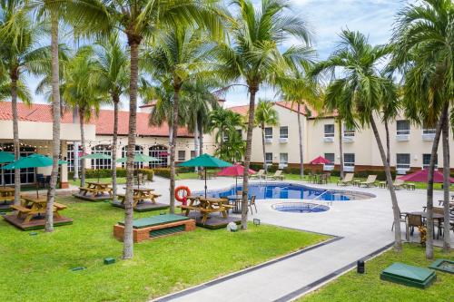 San Luis埃尔罗普埃托品质酒店的一个带游泳池和桌子以及棕榈树的度假村