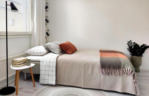拉赫蒂Beautiful studio in the heart of Lahti的一间卧室配有一张床、一张桌子和一个窗户。