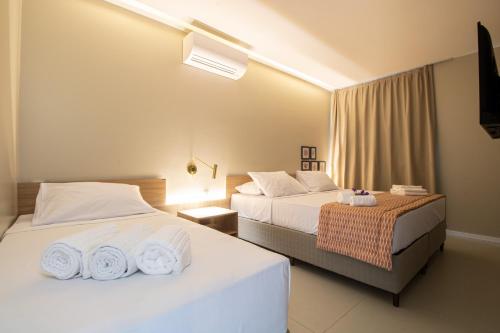 IpiocaIpioca Beach Resort的酒店客房设有两张床和电视。