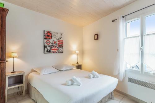 拉弗洛特Nice studio with veranda nearby the beach in La Flotte - Welkeys的卧室配有白色的床和窗户。