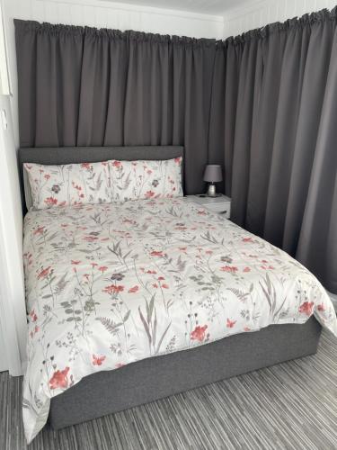 卡林顿The Garden Room - A cosy country stay in Cornwall的一间卧室配有一张带花卉床罩的床