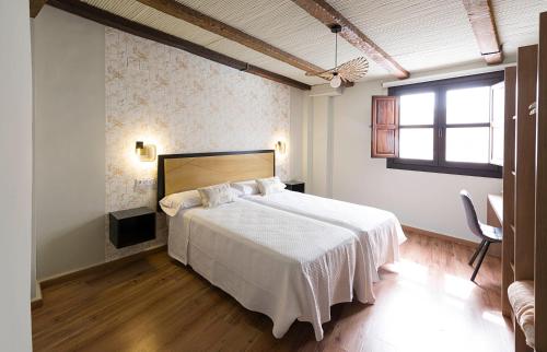 乌贝达Hotel Juancaballo的卧室配有白色的床和窗户。
