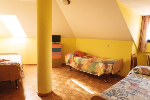 阿斯托加Vut RAQUEL的阁楼卧室配有两张床和柱子