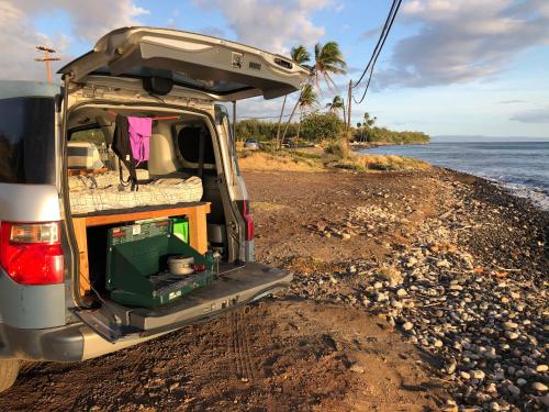 Ah Fong VillageGo Camp Maui的停在海滩上的一辆面包车,后开