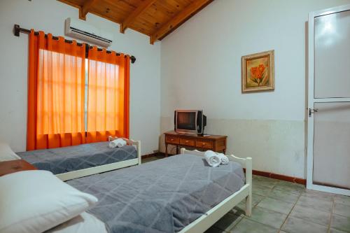 伊瓜苏港帕罗奥罗莎酒店的一间卧室设有两张床、一台电视和一扇窗户。