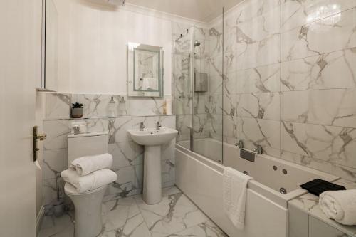 芬德霍恩Boutique Beachside Apartment with Jacuzzi Bath, Findhorn的白色的浴室设有水槽和卫生间。