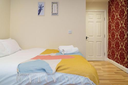 利兹Roundhay Apartments的一间卧室配有一张带彩色毯子的床