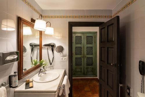 阿尔玛格鲁帕拉朵阿尔马格罗酒店的一间带水槽、镜子和门的浴室