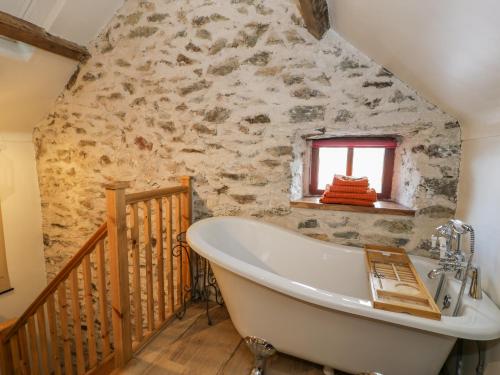 霍利黑德Cwch Gwenyn的带浴缸的浴室和石墙